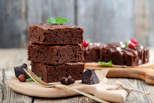 Chocolate brownie cake, dessert with nuts on wooden background.