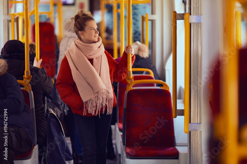 Young pretty girl stand in the tramway and look at window