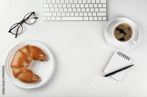 Composition with fresh tasty crescent roll on white background