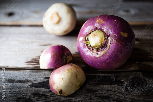 three rutabaga lying on rustic wood background.