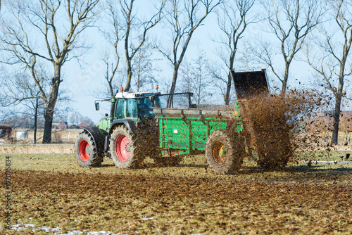 Tractor with manure spreader on the field - 1408