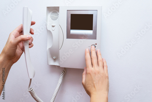 Woman hands opening door through intercom