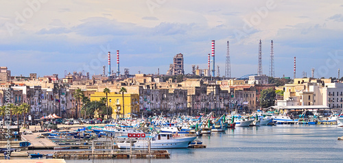 Taranto old town on the sea, fishing boats, docks, industrial plant on background