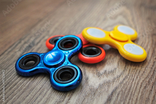 Group of colourful fidget spinner stress relieving toy on wooden background. 