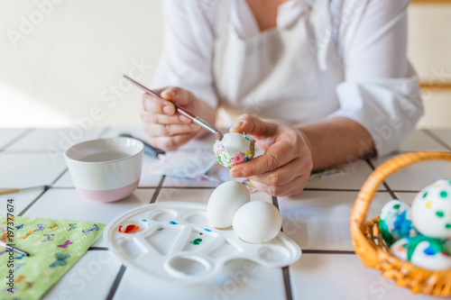 Woman decorating eggs with decoupage technique 