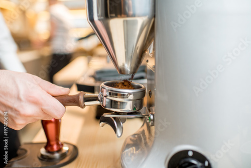 Grinding a coffee into the handle of the professional coffee machine