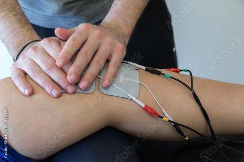 electronic therapy on knee used to treat pain. selective focus