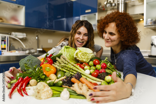 Woman with a big pile of vegetables in the kitchen