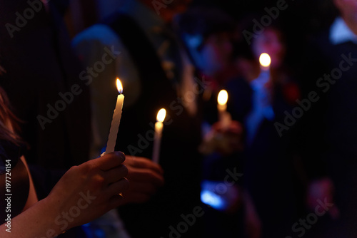 People hold candles light at dark scene