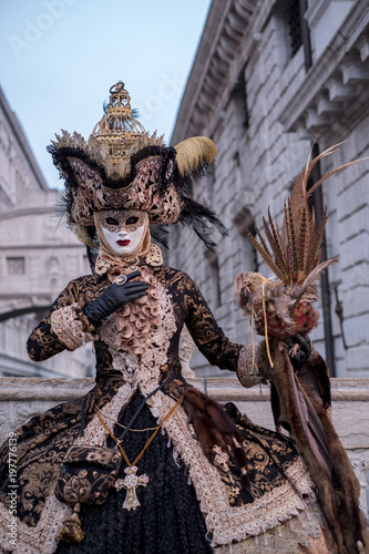 Woman in costume and mask, carrying feathered bird and birdcage, photographed during the Venice Carnival (Carnivale di Venezia)