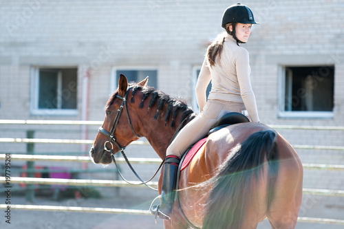 Young lady riding a horseback at equestrian farm