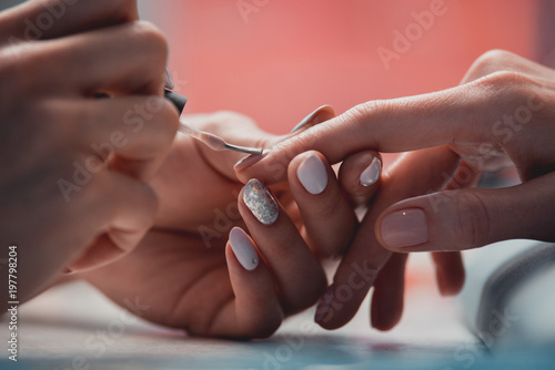 Close up female hands painting nails while locating on table