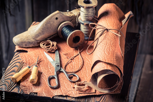 Cobbler workplace with tools, leather and threads