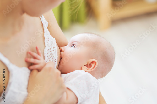 Young mom breast feeding her newborn child. Lactation infant concept. Mother feed her baby son or daughter with breast milk