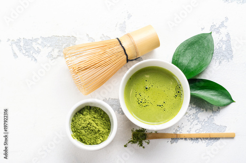 Green matcha tea drink and tea accessories on white background