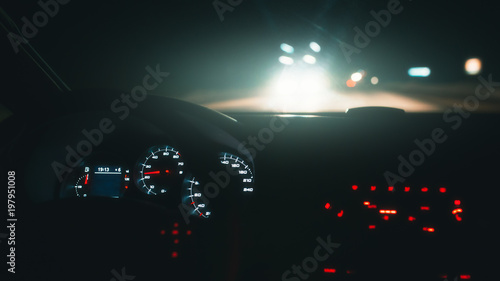 Driving car at night highway. Inside interior view. Illuminated dashboard