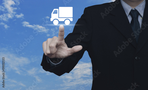 Businessman pressing truck delivery icon over blue sky with white clouds, Business transportation service concept