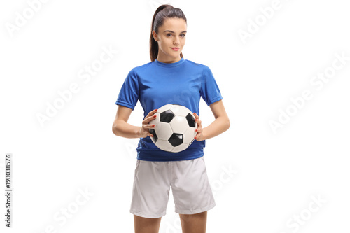 Female soccer player holding a football