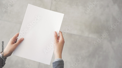 Person holding white empty paper