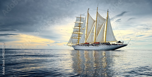 Sailing ship against the background of beautiful sky and ocean. Yachting. Sailing