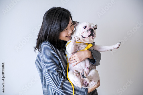 Asian woman hugging dog