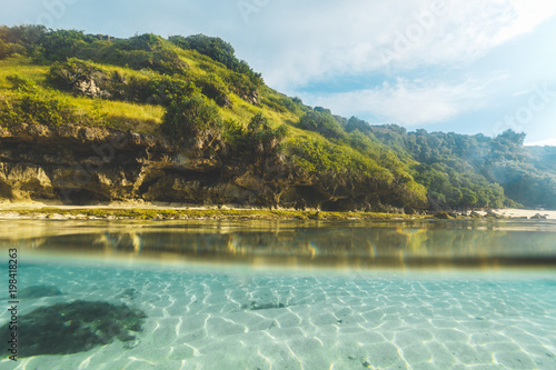 Tropical sand beach split above and below water, Bali, Indian Ocean