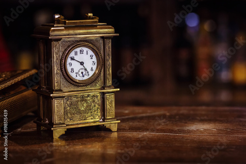 antique clock stand on a wooden table