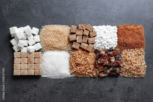 Flat lay composition with different types of sugar on gray background