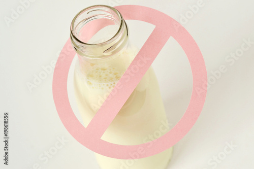 Glass bottle of milk with restriction sign - Lactose intolerance concept