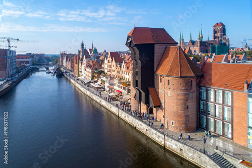 Gdansk old city in Poland with the oldest medieval port crane (Zuraw) in Europe, St Mary church, Motlawa River, bridges and tourist ships. Aerial view.