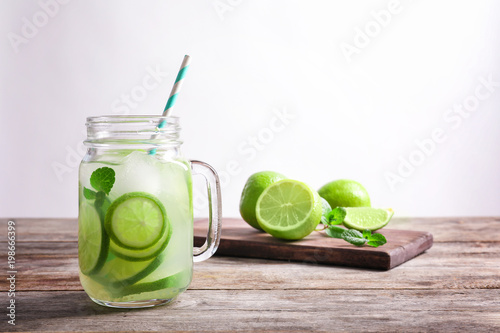 Tasty lemonade with lime in mason jar on table