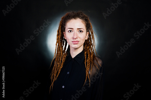 Studio shoot of girl in black with dreads at black background with nimbus.