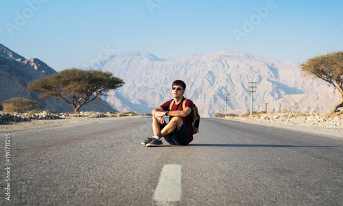 Man sitting on the empty dessert road