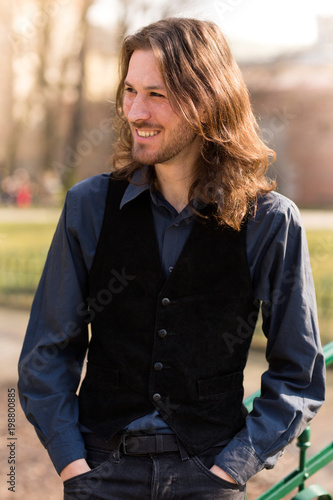 Przystojny uśmiechnięty chłopak z długimi włosami