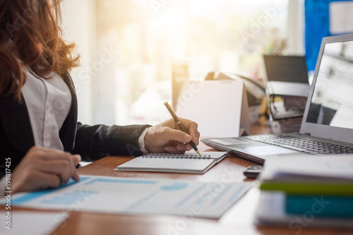 Business woman at working with financial reports and laptop computer in the office