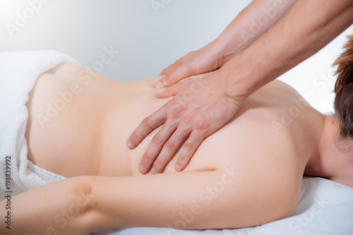 doctor massaging the back of a young woman