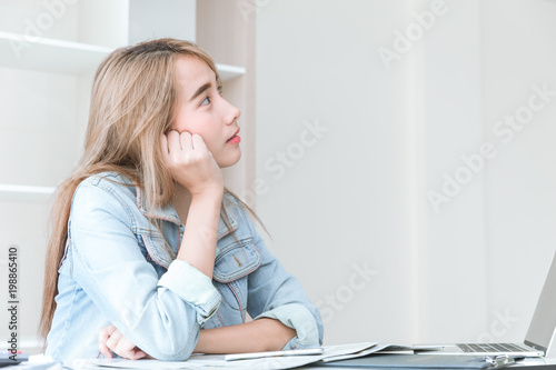 Asian young employee thinking or inattentive imagination dream while working in the office