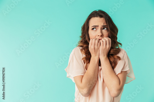 Portrait of a frightened young girl in dress looking away