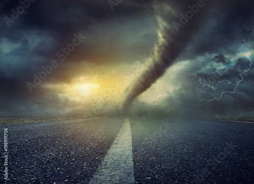 Powerful huge tornado twisting on road
