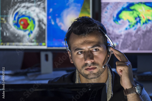 Meteorologist monitoring storms on his computer screens, close up shot