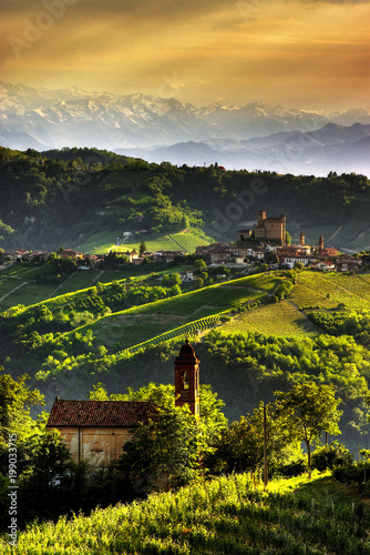 View of Serralunga d'Alba with the sun that draws the ripples of the hills. We are in the wine producing area of Barolo. UNESCO World Heritage Site.