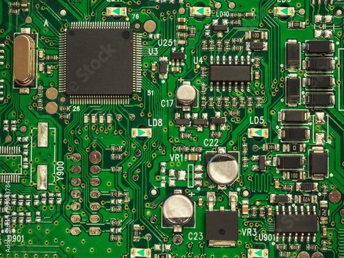 Close-up of electronic circuit board PCB with components: microchip, processor, integrated circuits, capacitors, resistances and electronic connections are noted. High-quality macro photography.