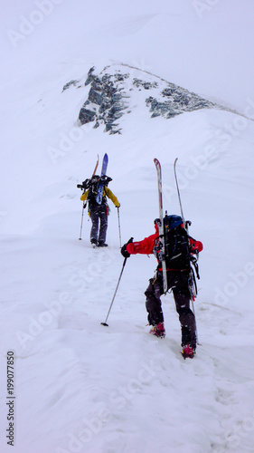 two male mountain climbers on a backcountry ski mountaineering tour in bad weather