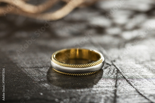 Silver and gold ring on black background