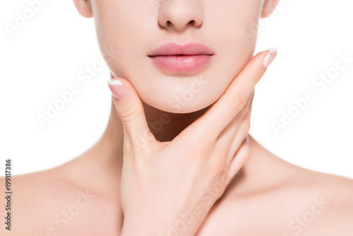 cropped shot of young woman touching her chin isolated on white