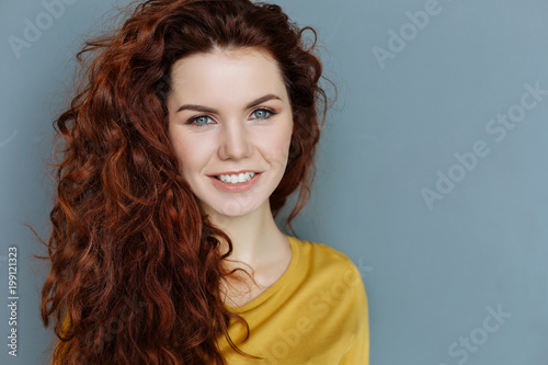 Beautiful face. Portrait of a cheerful delighted nice woman looking at you and smiling while being in a good mood