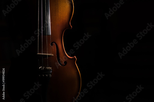 Violin on a black background lit from one side