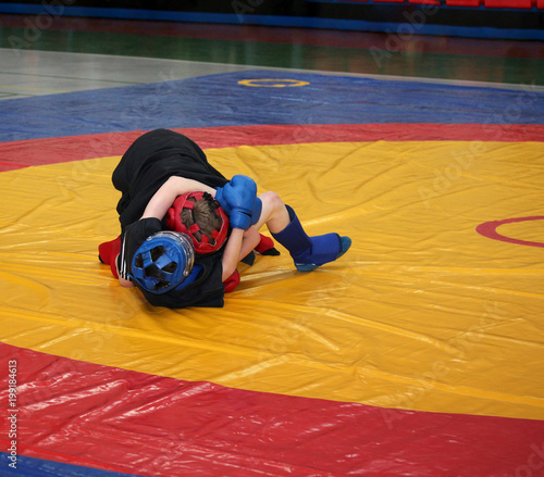 Two boys are fighting on the wrestling mat