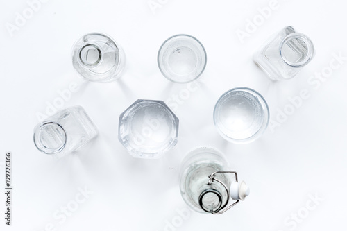 Drinks on the table. Pure water in jar and glasses on white background top view