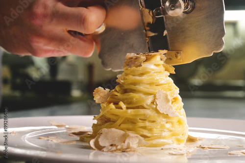 Egg pasta dish, typical Italian, with fine white truffle grated on top. Concept of: gourmet cuisine, truffles, Italian pasta, fine dishes.